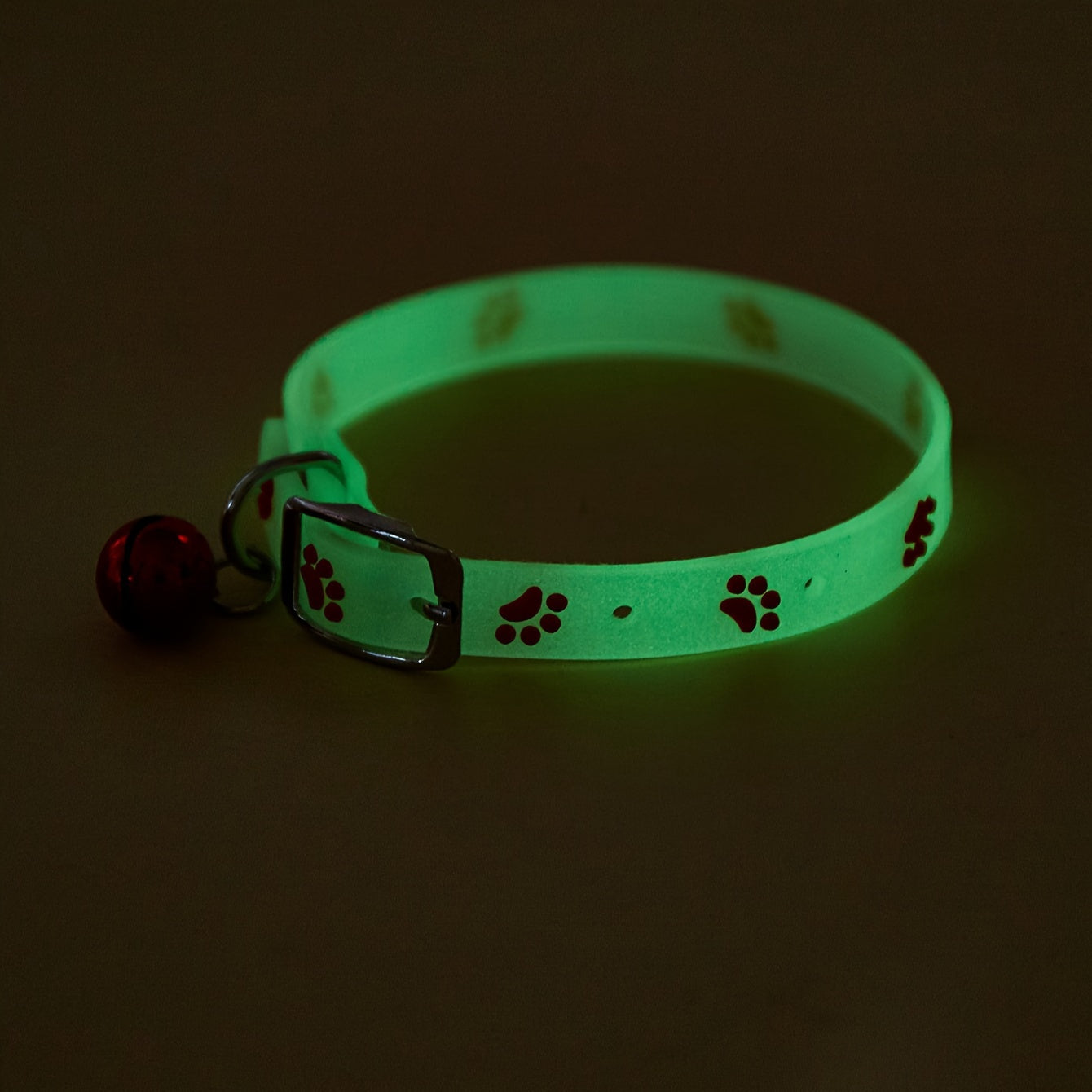 Adjustable glow-in-the-dark cat collar with colorful paw print for easy spotting at night.