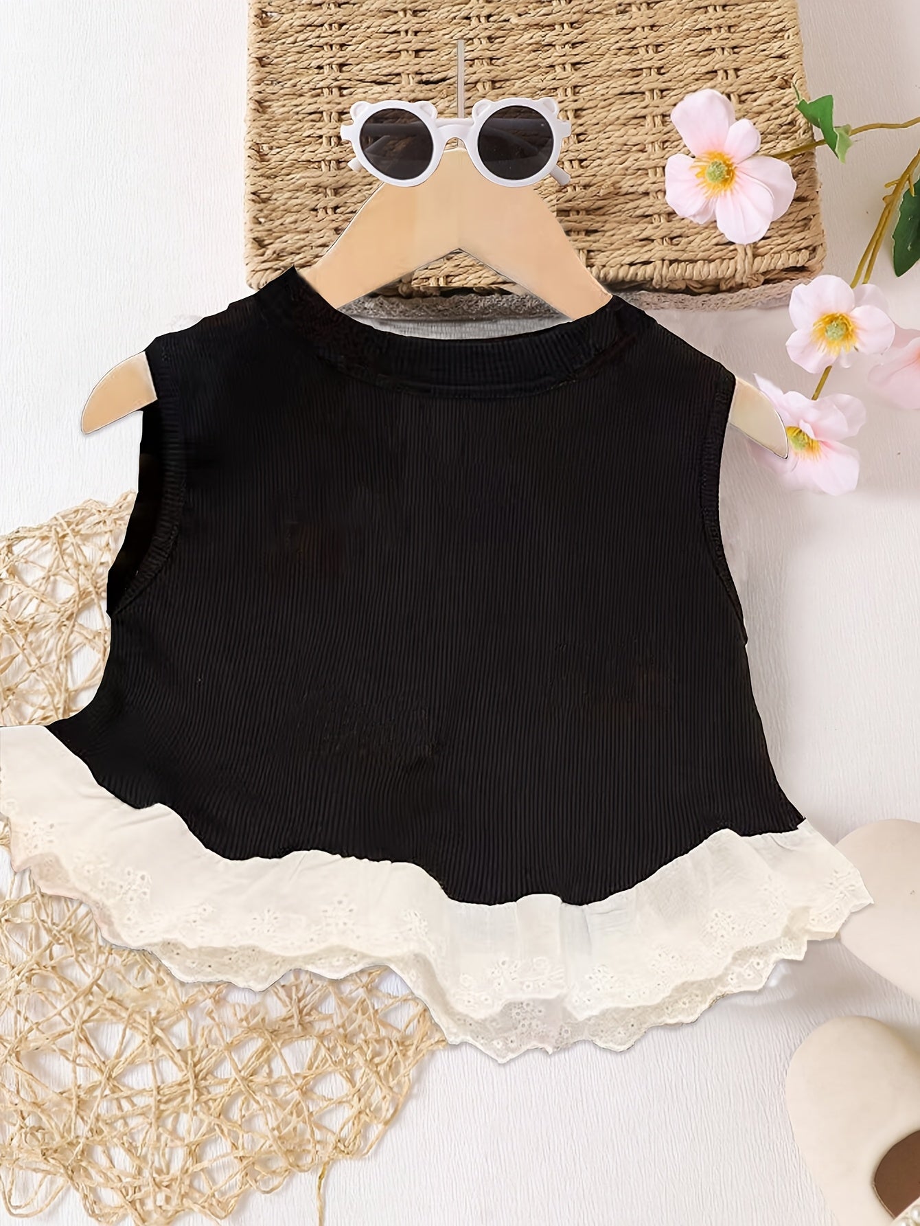 Girls' summer camisole with lace trim, bow decoration, ruffle hem, and sweet top design.