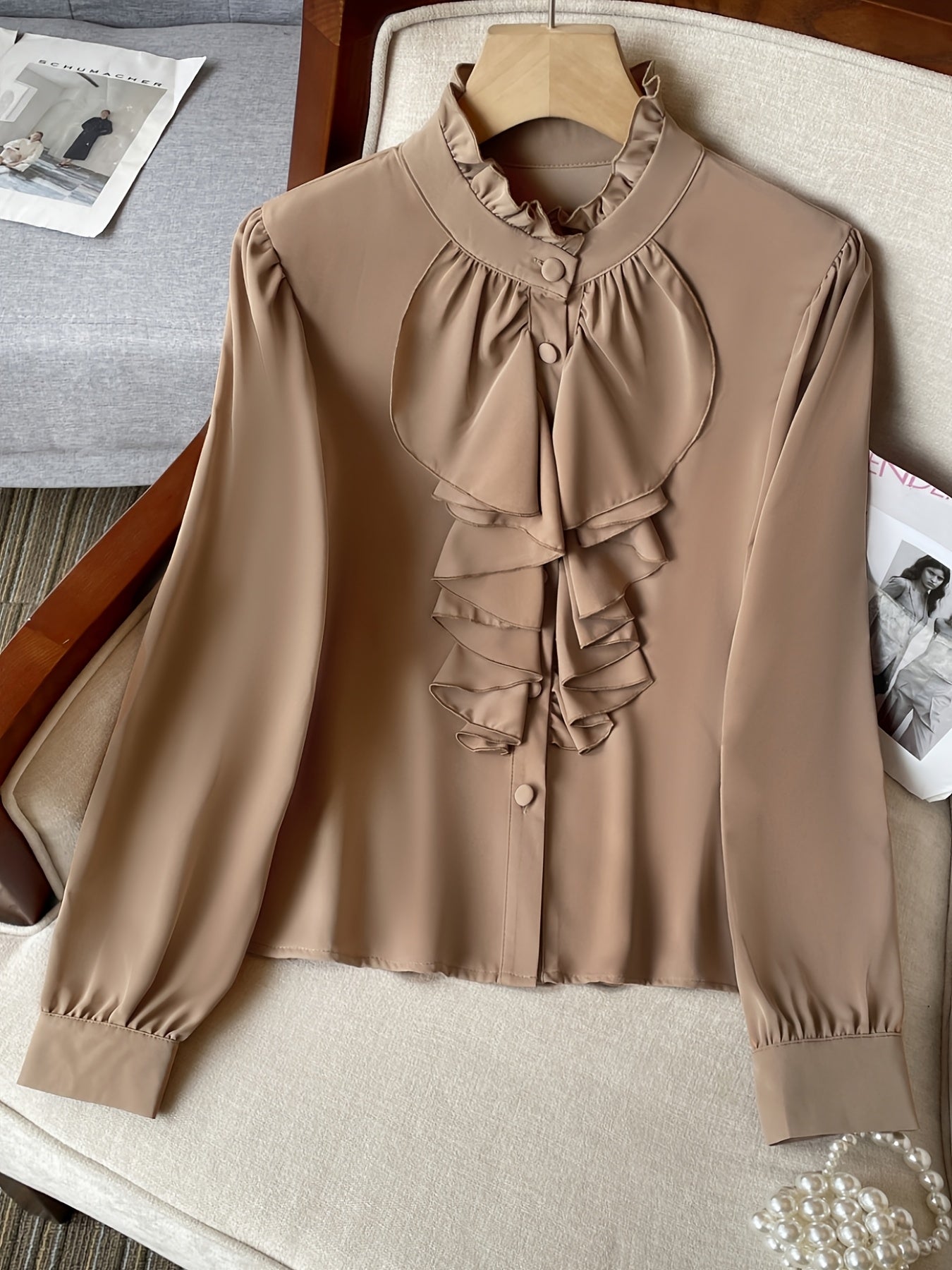 Stylish polyester blend blouse with ruffle detail, stand collar, and button front. Suitable for spring, summer, and fall.