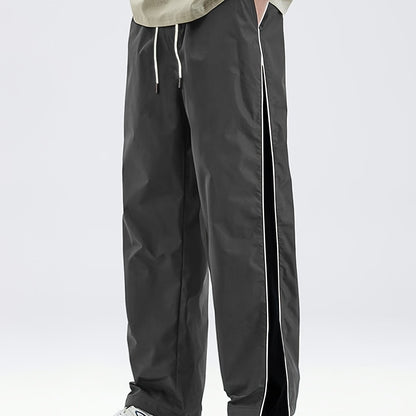 Men's black lightweight joggers with drawstring waist, perfect for spring and fall. Made of polyester fabric with a loose fit and glossy finish.