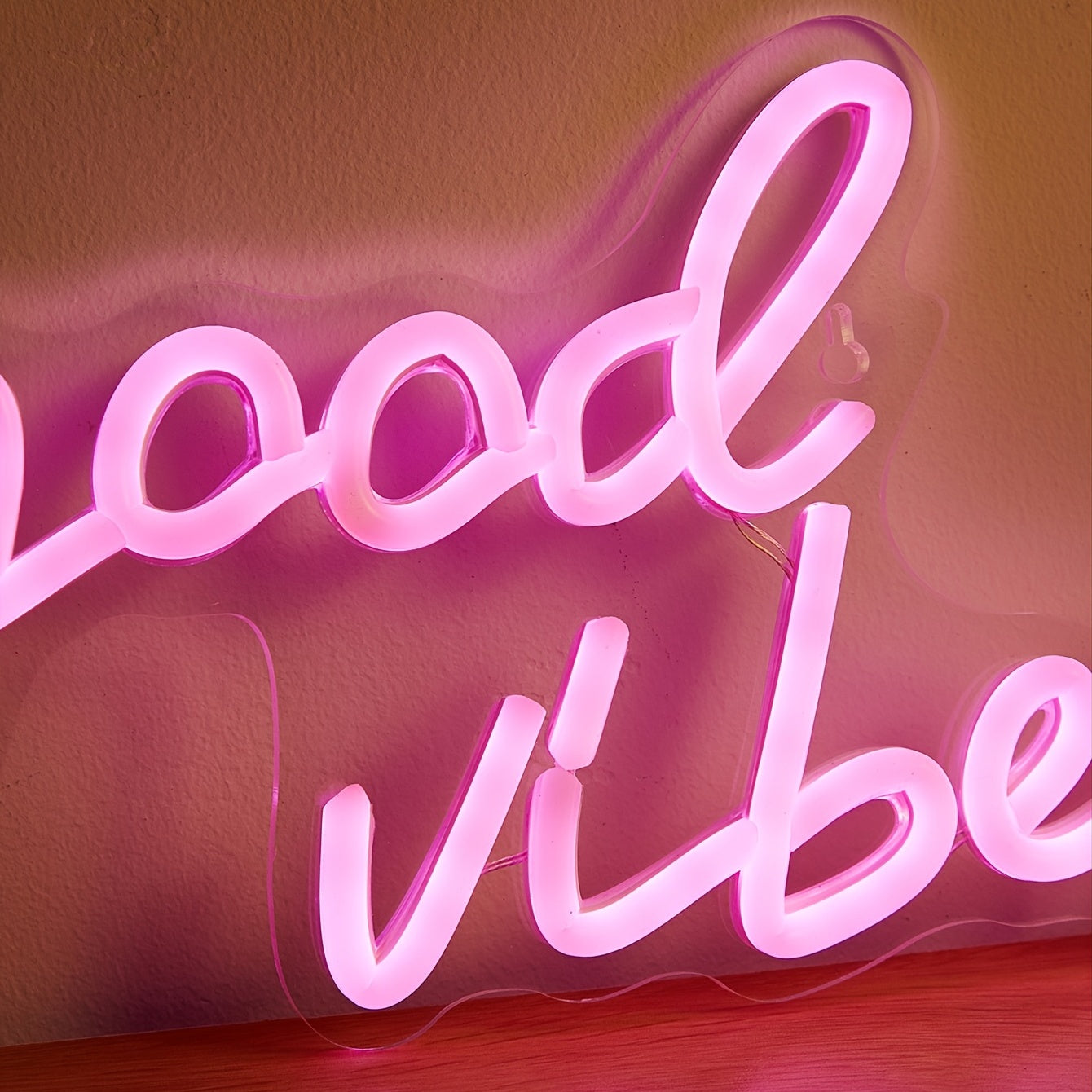 Pink cursive "Good Vibes" LED neon sign, USB powered for wall decor in bedroom, bar, or party atmosphere.