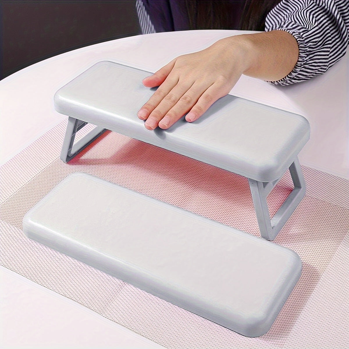 Single folding nail armrest for manicurists, with hand support and wrist rest for salon use.