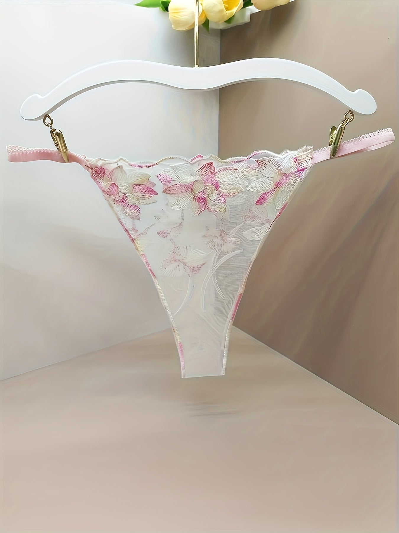 Women's sheer mesh thong panties with embroidered floral design and open crotch, featuring bow detail. Soft and breathable lingerie.