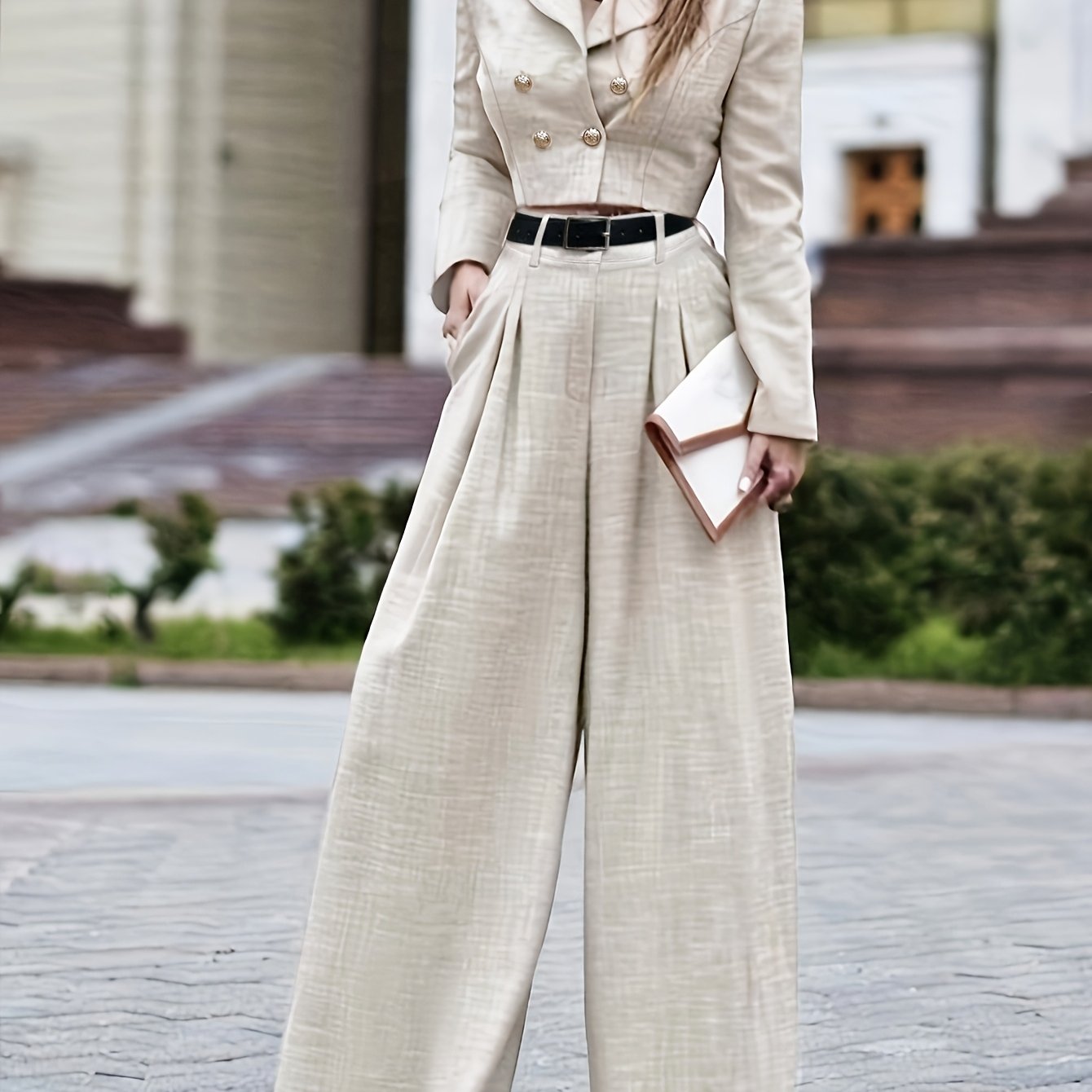 Stylish beige two-piece suit with long sleeves, wide lapels, high-waisted pants, and accessory bag. Ideal for fall/winter workwear.