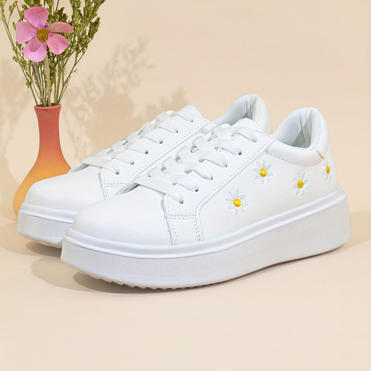 Women's low-top lace-up sneakers with embroidered daisy design, ideal for all seasons.