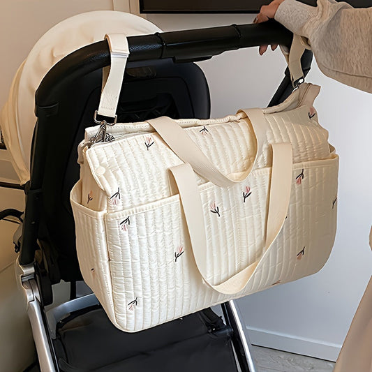 Large-capacity parent bag with a stylish print, designed for travel and diaper storage, featuring a trolley attachment for added convenience.