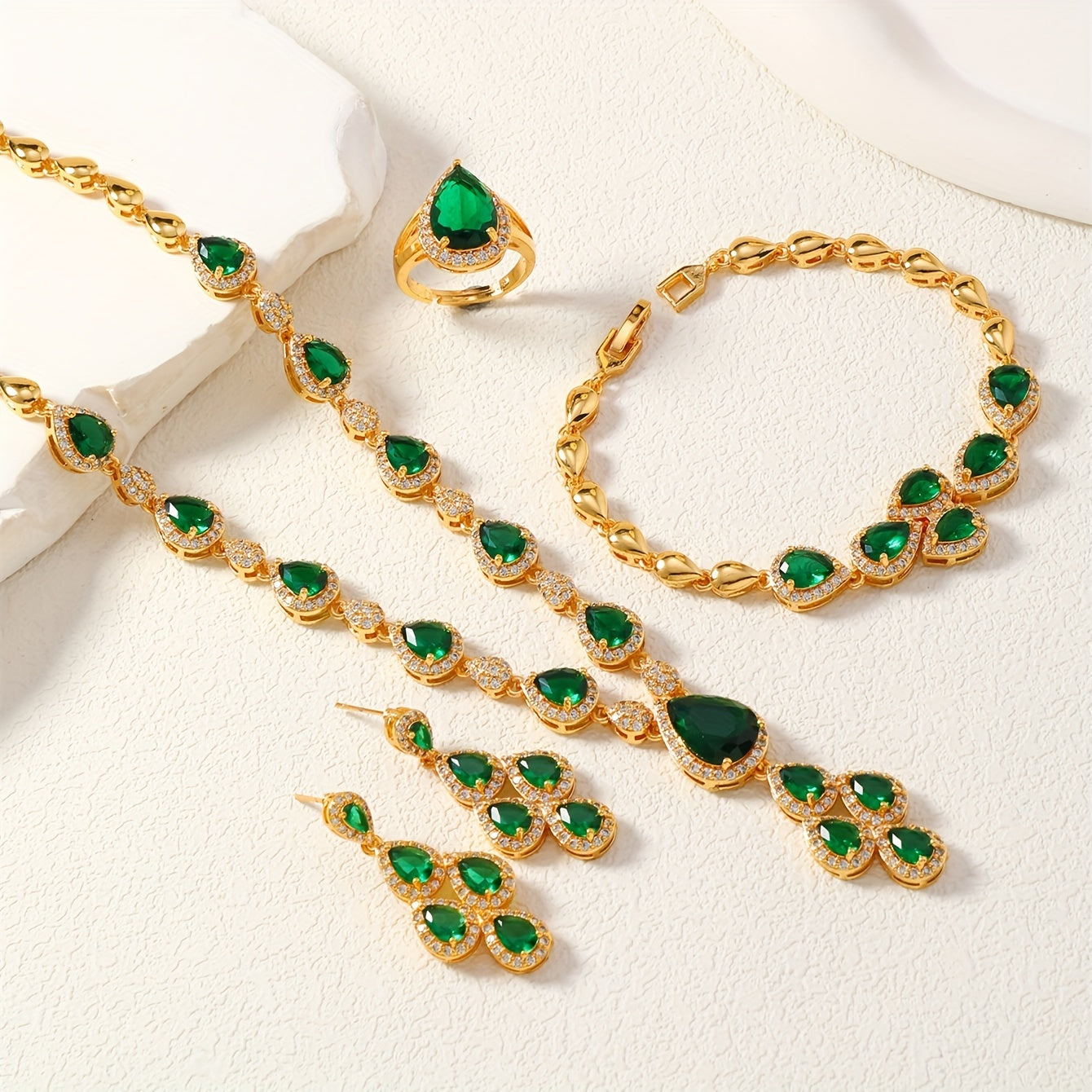 A set of four pieces of stunning Middle Eastern women's wedding jewelry from Saudi Arabia, featuring full inlay peacock green water drop-shaped cubic zirconia on copper. The set includes one necklace, one bracelet, one ring, and one pair of earrings.