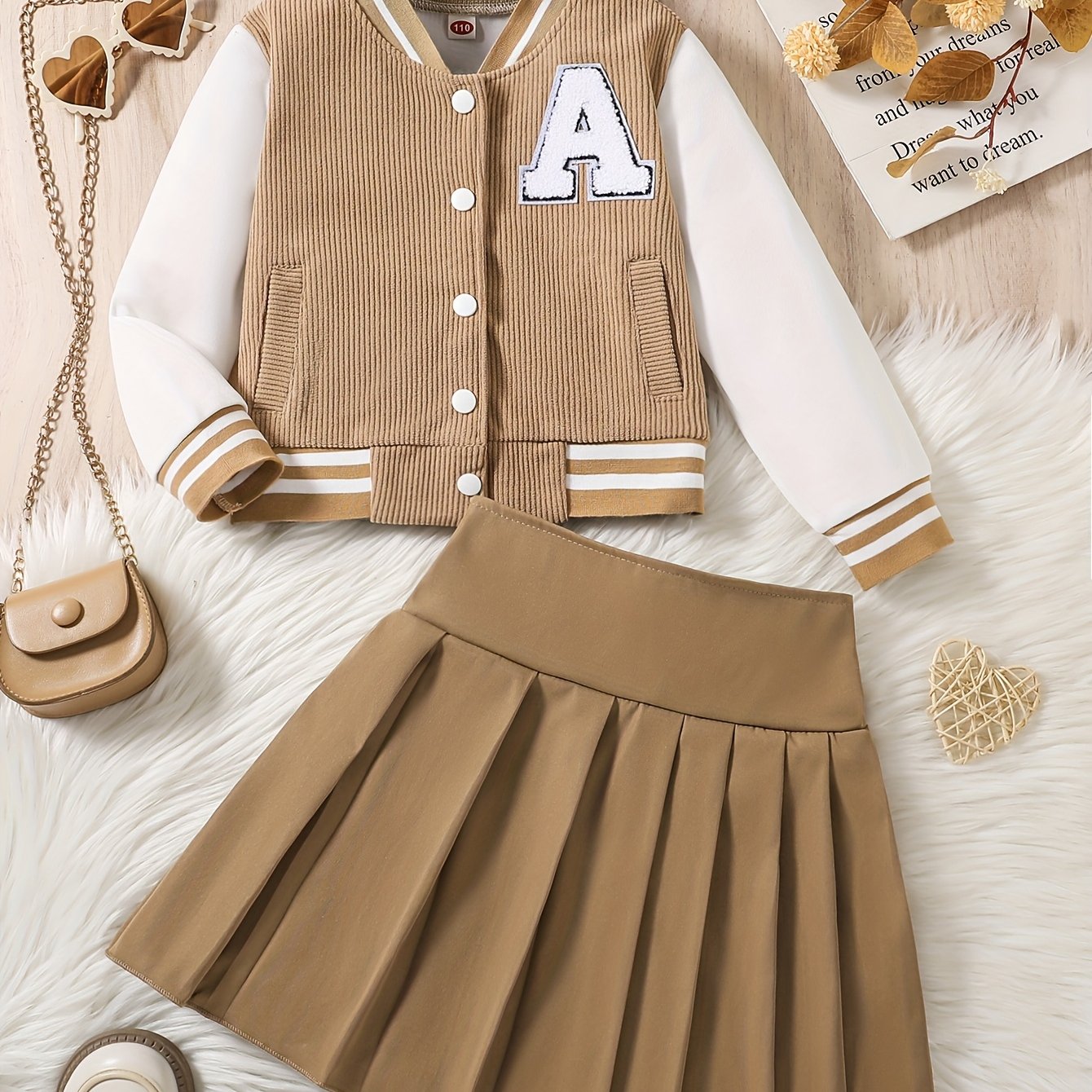 Set of 2 includes a baseball jacket with embroidered letters and a pleated skirt.