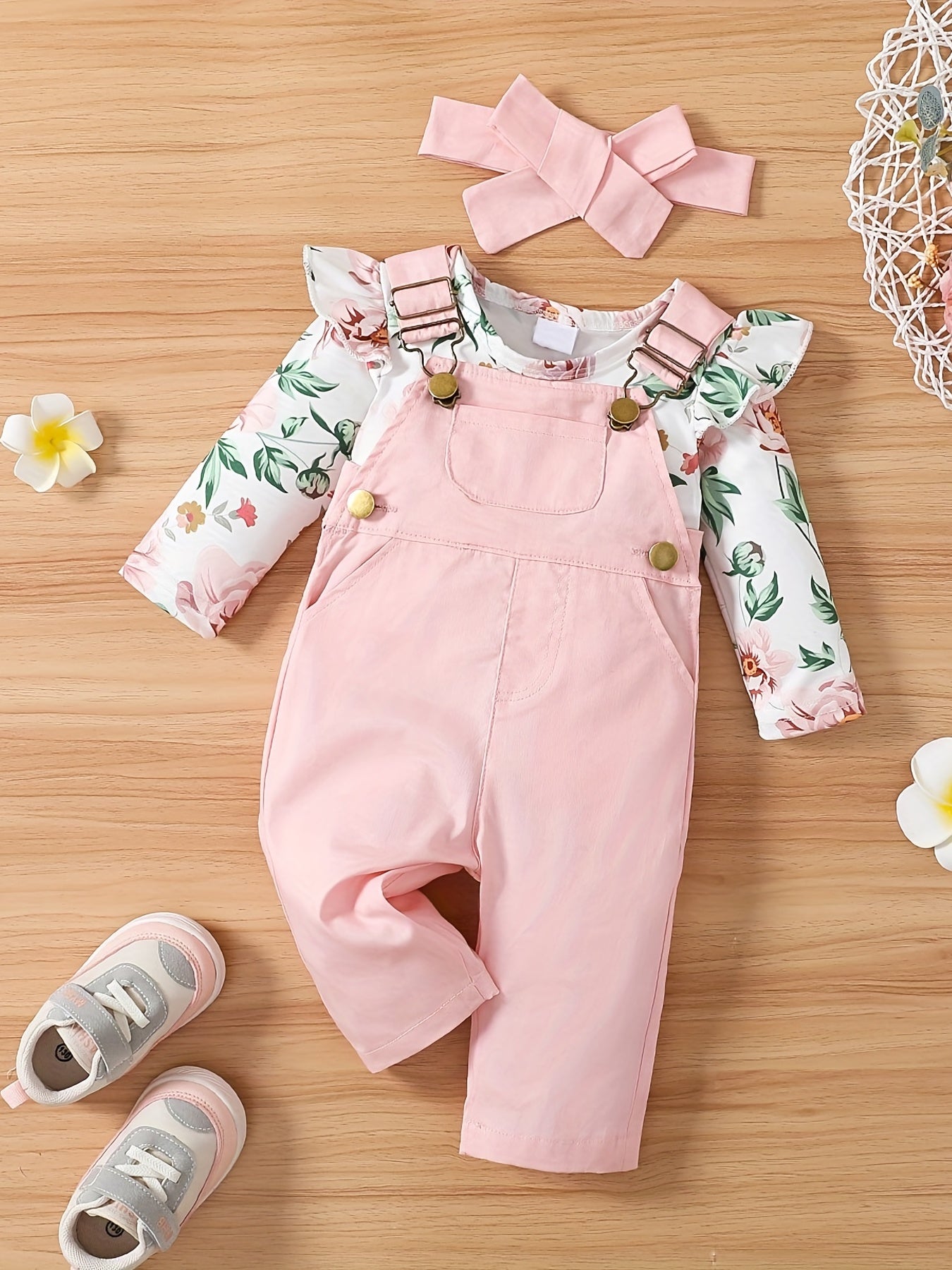 Girls 3-piece cotton set includes adjustable strap pants with pockets, floral print long sleeve romper with ruffle shoulder, and bow headband. Perfect for outdoor wear in spring/fall.