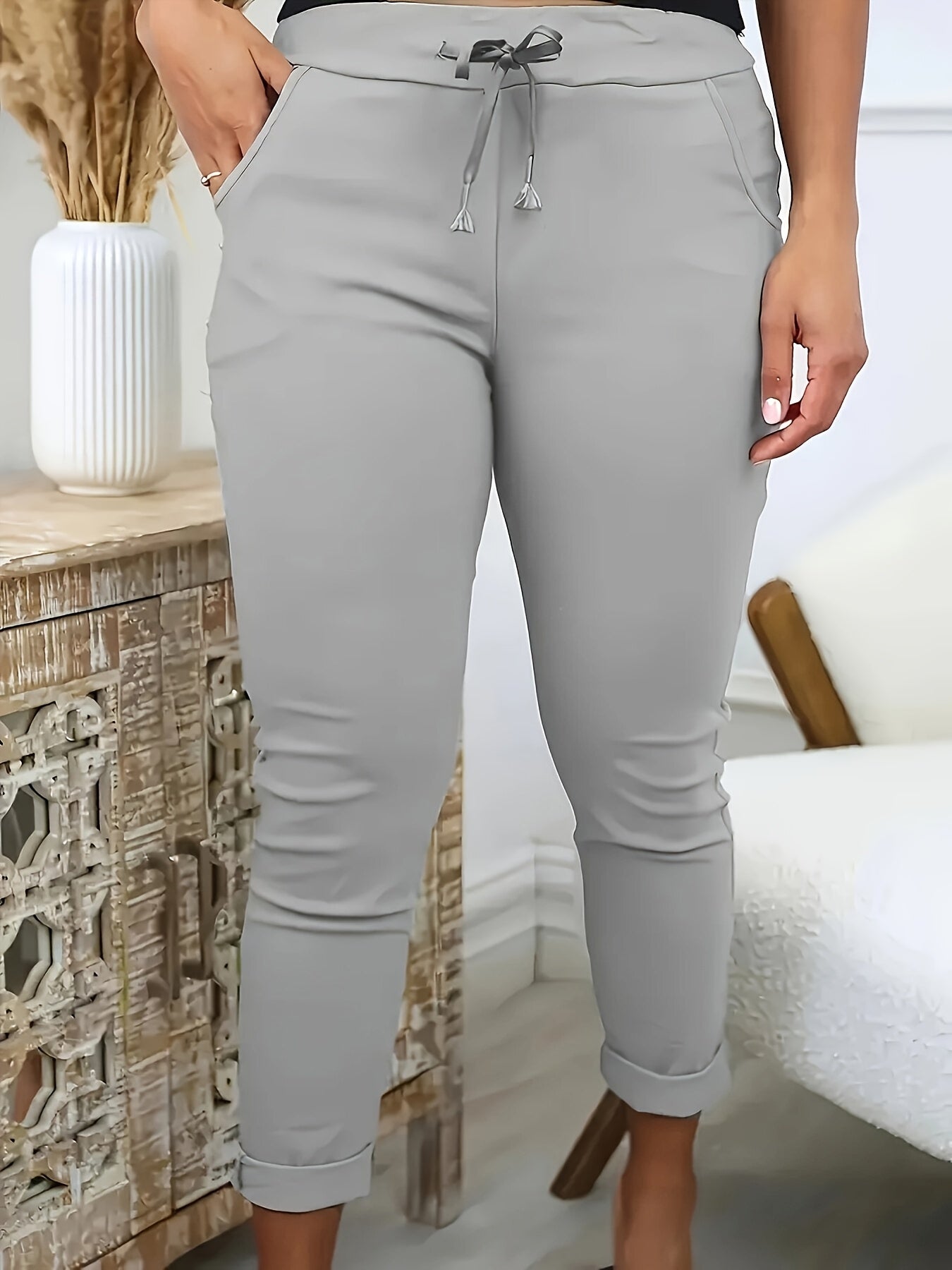 Machine-washable plus-size skinny pants in solid color polyester knit with medium stretch, elastic drawstring waist, and front pockets.