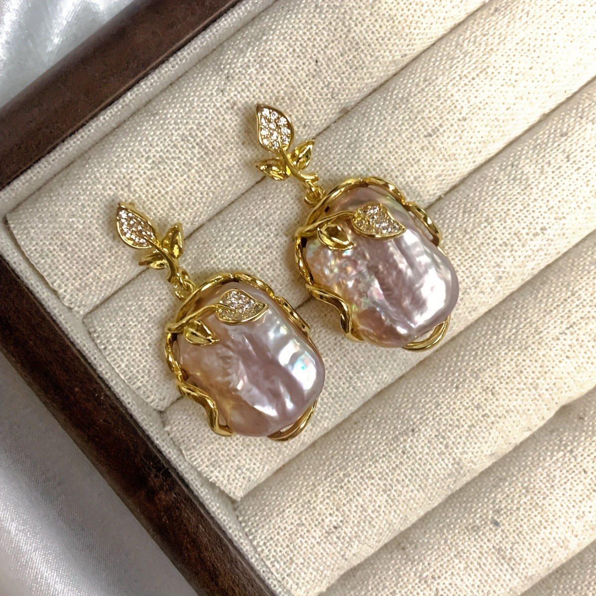 Elegant and luxurious French-inspired freshwater pearl earrings with gold-plated silver leaf accents, perfect for fashion-forward women with a taste for retro style and natural beauty.