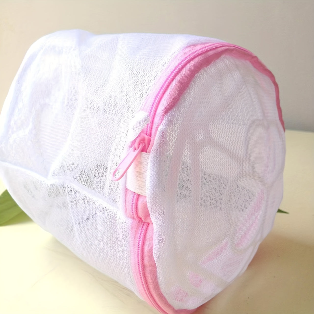 Pink zipper polyester mesh laundry bag, machine wash safe, anti-deformation for delicates and underwear, hexagonal pattern, laundry room accessory.