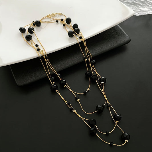 Vintage-style necklace featuring black glass beads in multiple layers for an elegant and long neck chain. Can be worn as a sweater chain or as a statement accessory piece of jewelry.