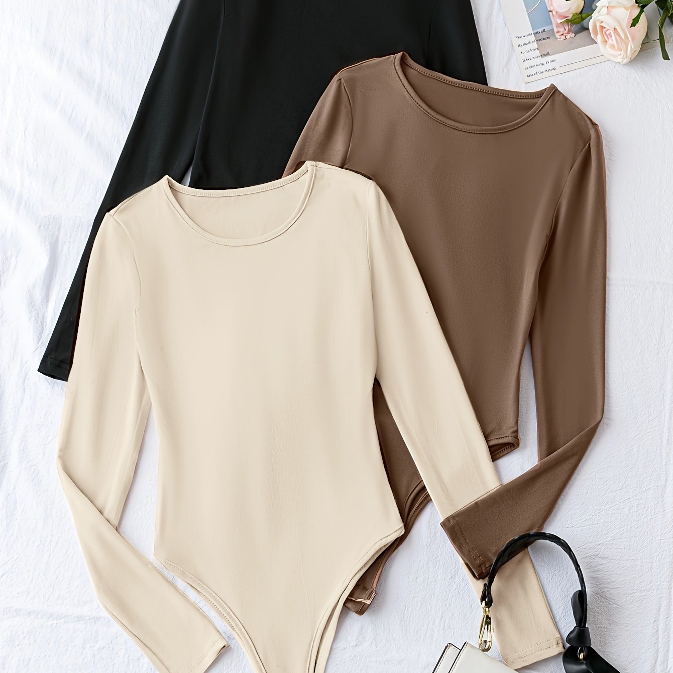 Pack of three solid crew neck long sleeve bodysuits for women. Casual one-piece clothing.