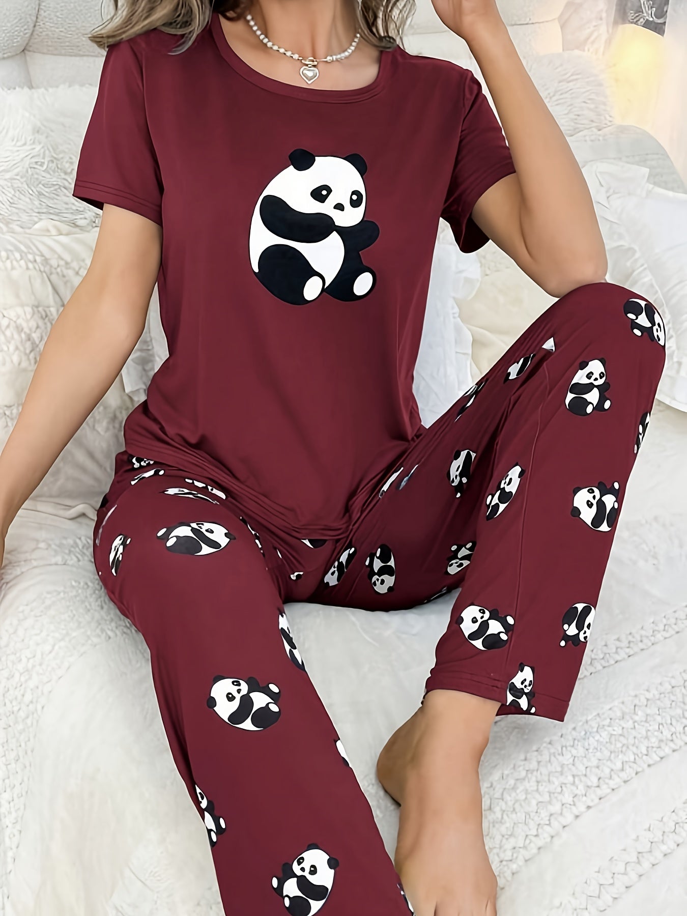 Women's sleepwear set with cute panda print, short sleeve top, and elastic pants.