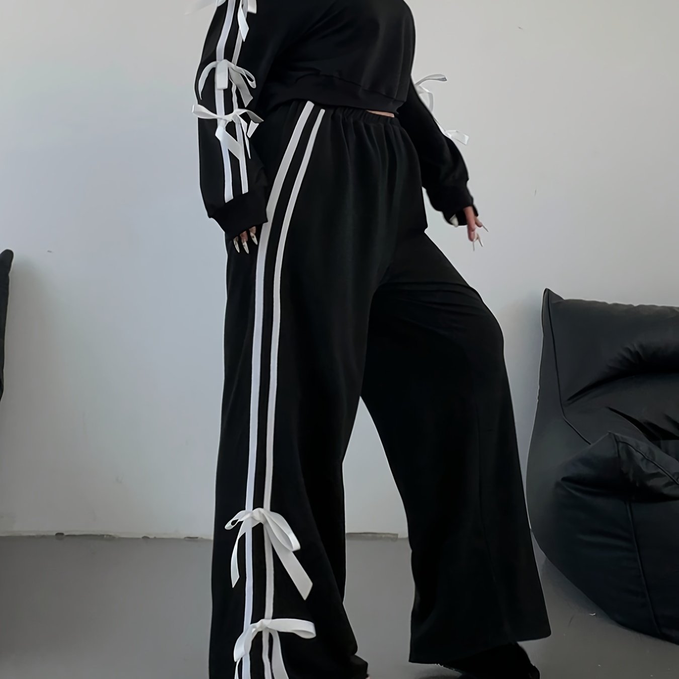 New two-piece set for plus size women with crop top, long sleeves, striped wide-leg pants, bow, and drawstring decorations.