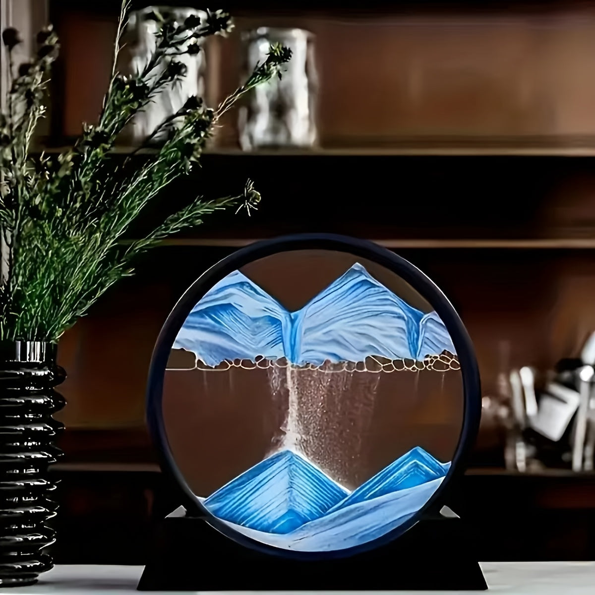 Large round glass frame with flowing sand creates a 3D deep sea scene as a relaxing home and office decoration.