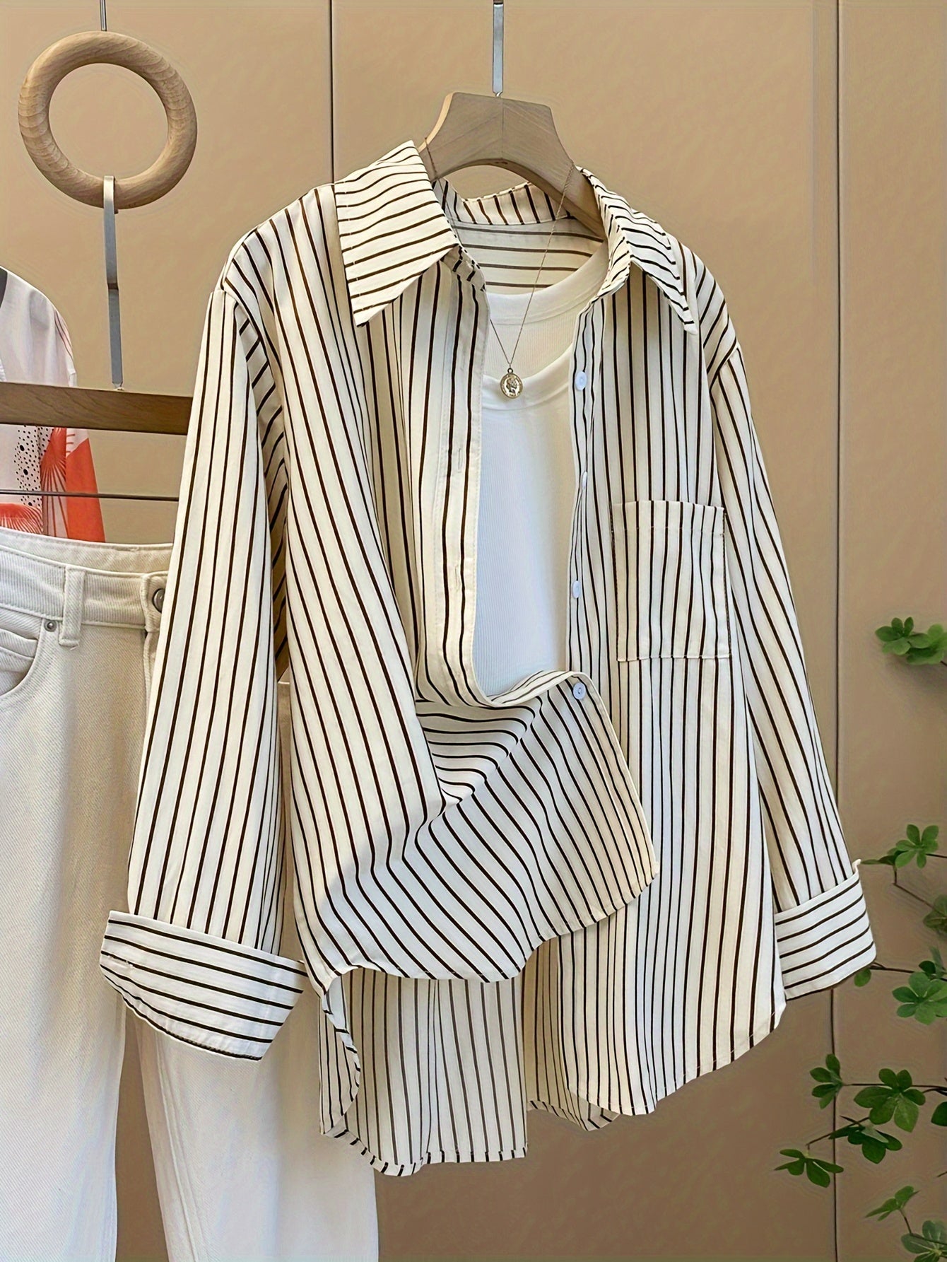 Striped blend shirt for women, with loose fit and ruffled hem detail. French-inspired chic look, perfect for casual wear.