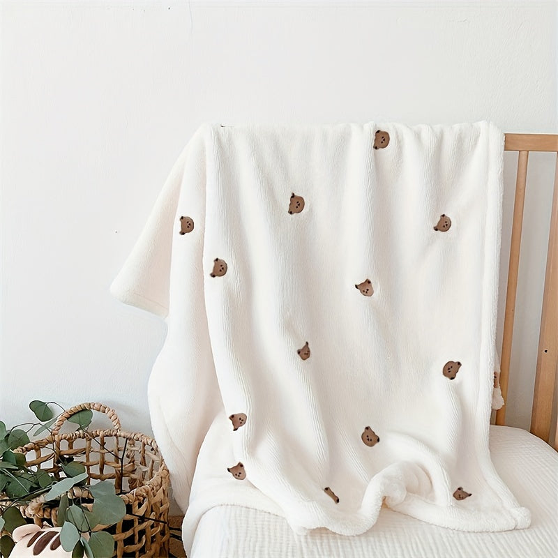 Soft polyester white blanket featuring an embroidered bear design, perfect for cozy youngsters.