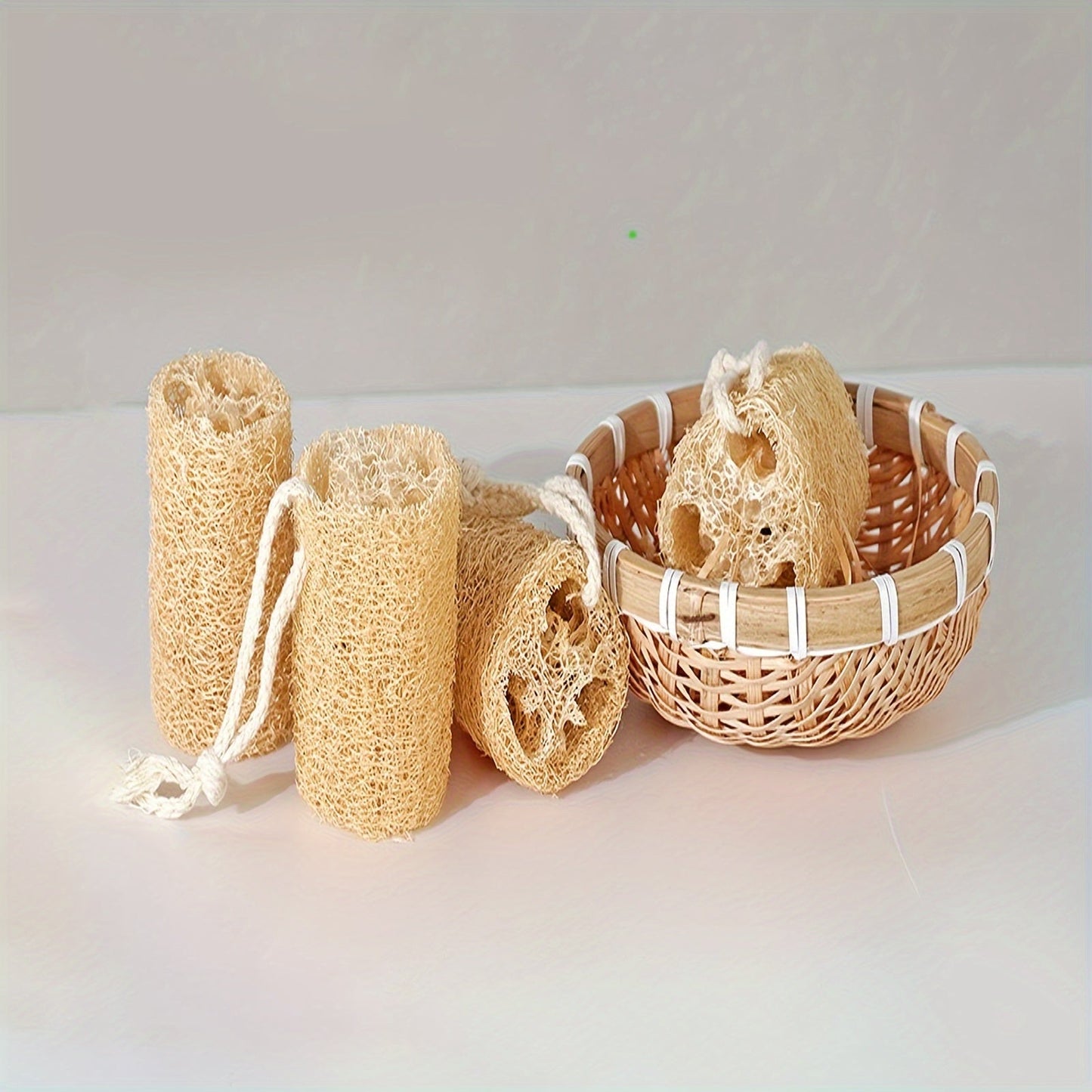 A set of four natural loofah sponges made from wood pulp fiber. These rectangular sponges are lightweight and made from non-woven fabric, making them reusable for various purposes such as bathing, spa treatments, skincare, kitchen cleaning, dishwashing