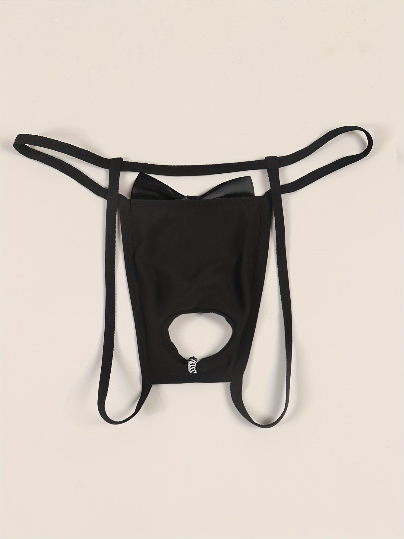 Sexy low-rise jockstrap for men with playful tie print and front bow detail. Breathable and stretchy black fabric with open crotch design for comfort and style.