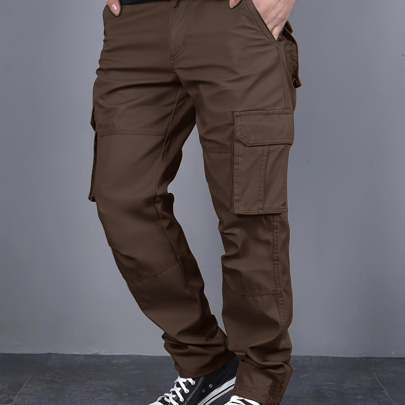 Solid color cargo pants with multiple flap pockets and a drawstring waistband, perfect for outdoor activities like hiking, fishing, and camping.