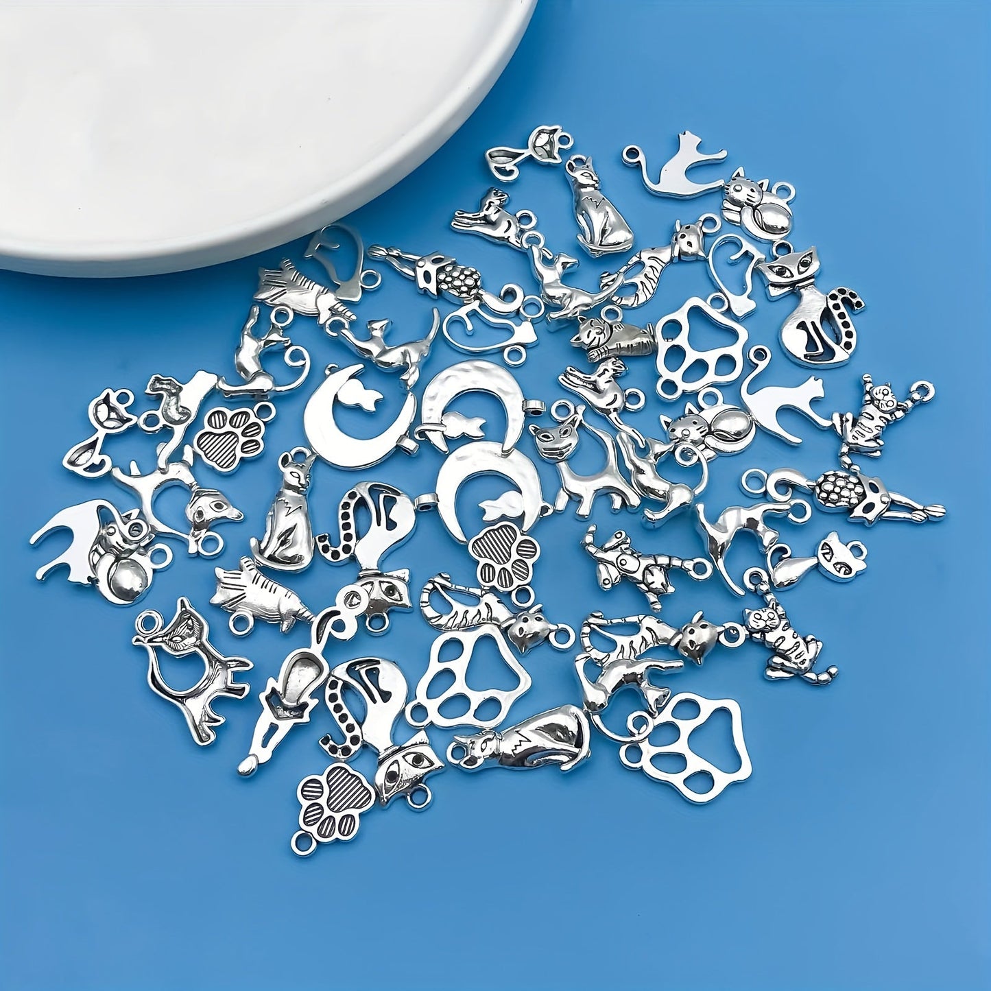 Create your own unique jewelry pieces with this set of 51 zinc alloy antique silvery animal series cat-shaped charms pendants. Perfect for DIY necklaces, bracelets, and earrings.