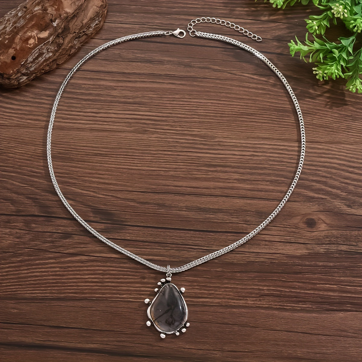 This stylish vintage-inspired silver herringbone chain features a large metal water droplet-shaped piece adorned with an ink flower pattern and a sizable resin pendant. Perfect for pairing with autumn and winter sweater outfits, it can be worn all year