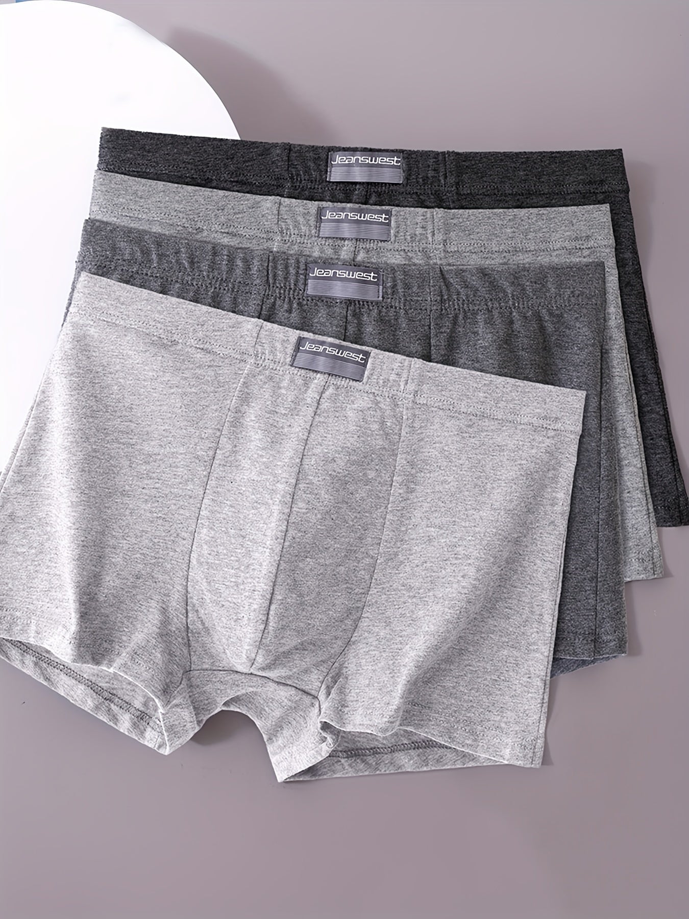 Men's 4-pack boxer briefs made of 95% elastane and 5% stretch knit fabric in solid colors.