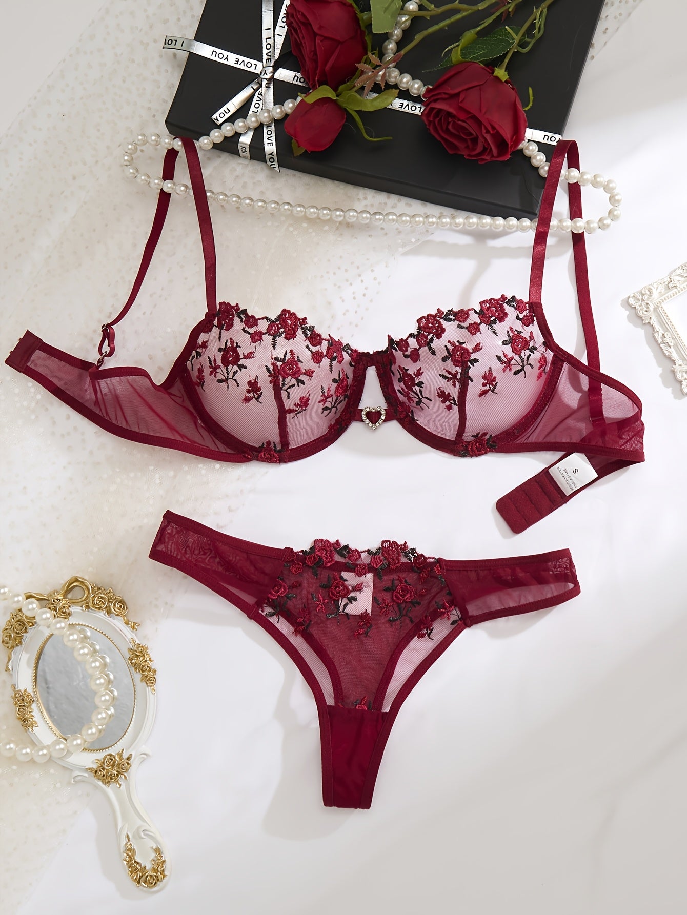 Red floral embroidered lingerie set for women with sheer mesh bra and low-rise panties. Hand washable, made from polyester and elastane blend.