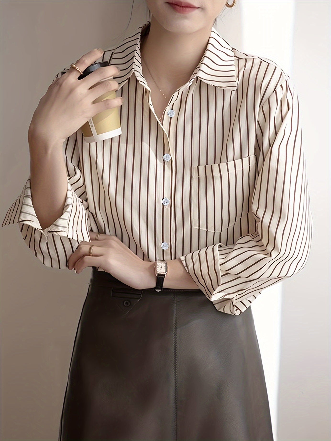 Beige striped blouse with button-up front, loose fit, machine washable.