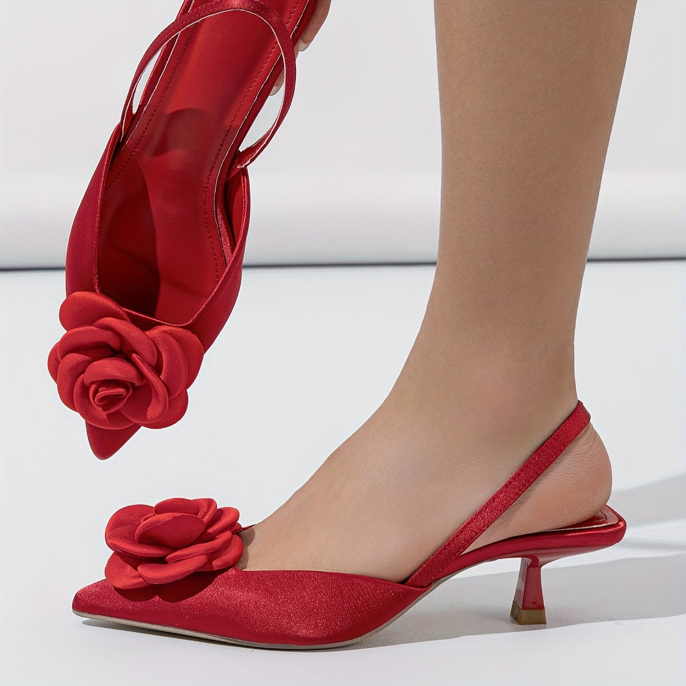 Pointed red high heel shoes with three-dimensional flowers, perfect for night weddings.