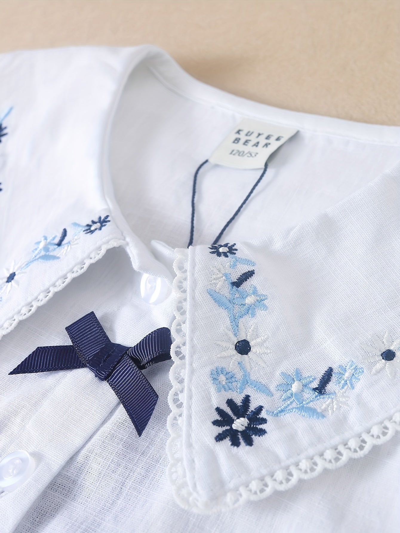 White cotton summer blouse with preppy doll collar, embroidered floral detail, Korean style, for middle and big kids.