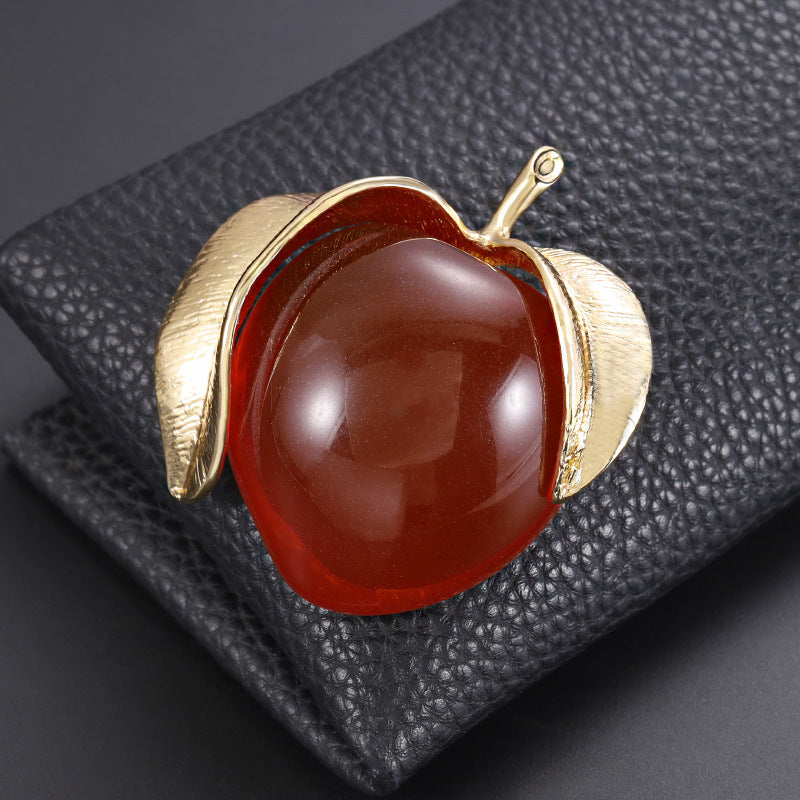 Vintage-inspired enamel brooch in a sophisticated peach design, featuring a high-end transparent finish. This fashionable fruit-shaped pin is a stylish accessory for clothing and suits.