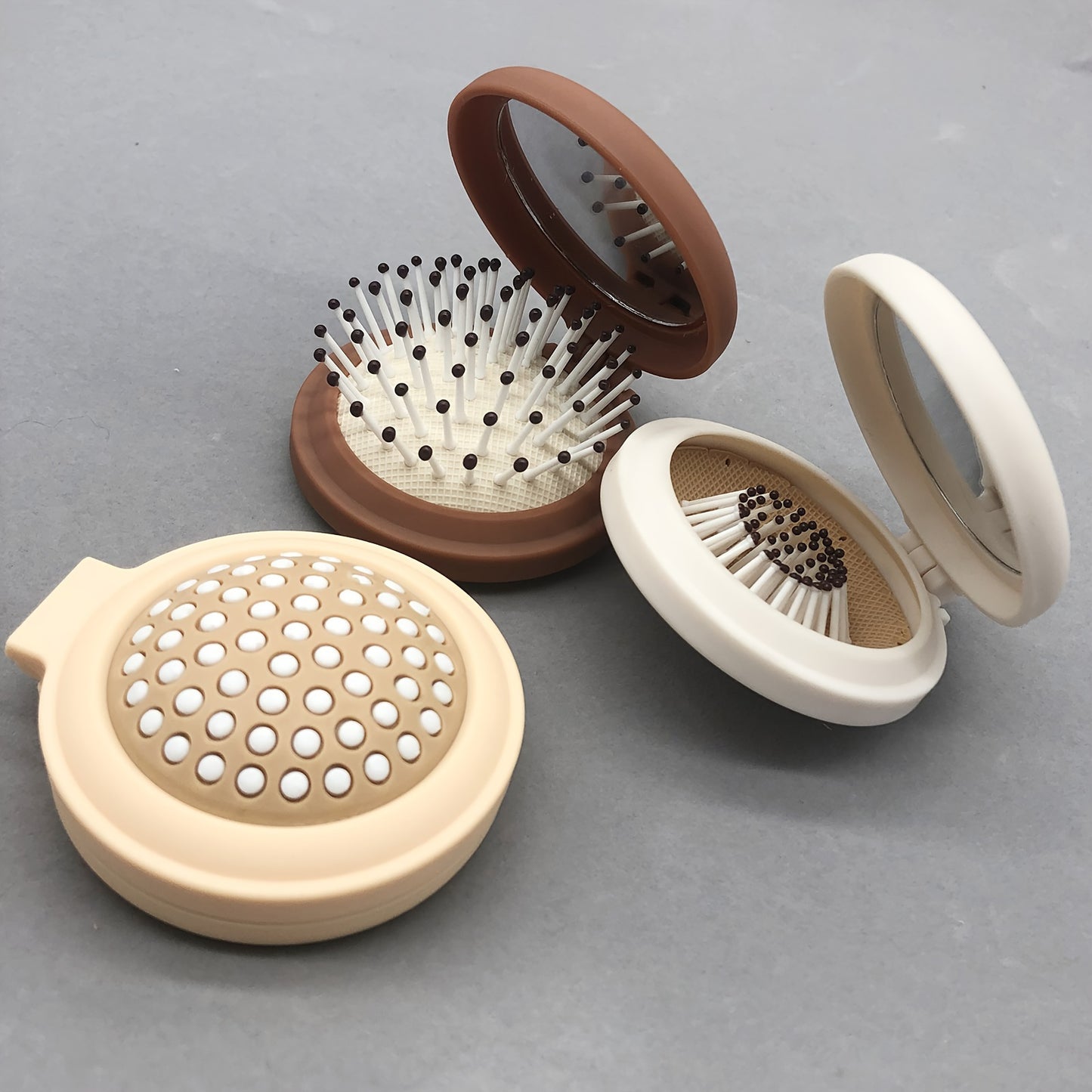 Portable makeup mirror with comb, foldable and multifunctional, convenient for outdoor use.