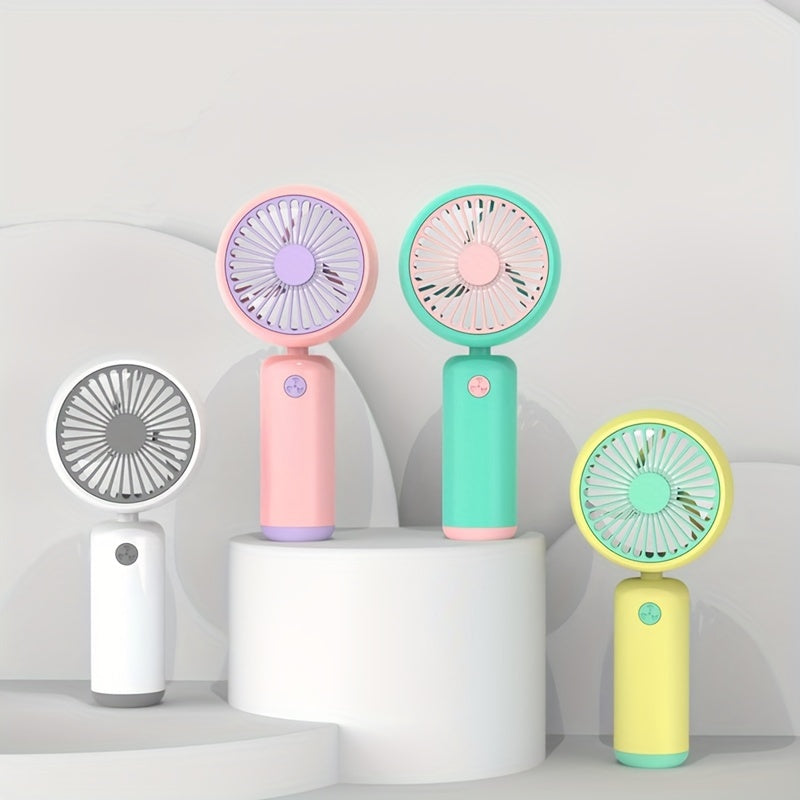 Small handheld portable fan with USB rechargeable battery, three adjustable speeds, and wearable design for use both indoors and outdoors.