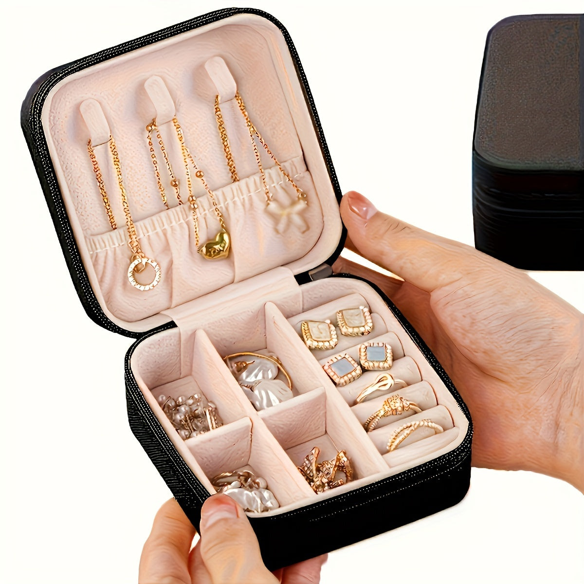 Stylish faux leather jewelry organizer box with pink interior for earrings, necklaces, and rings. Compact and portable with zipper closure. Multi-purpose travel case, no power needed.