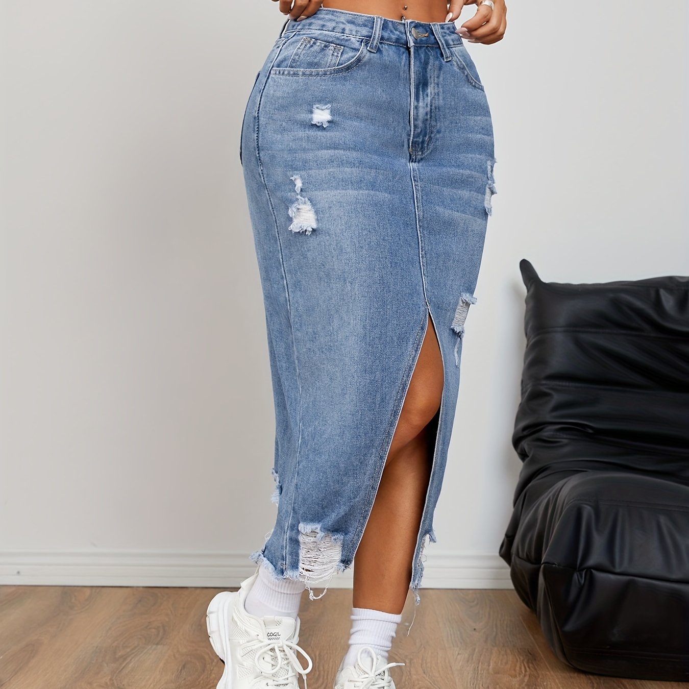 Casual distressed denim skirt with raw hem and slit for women.