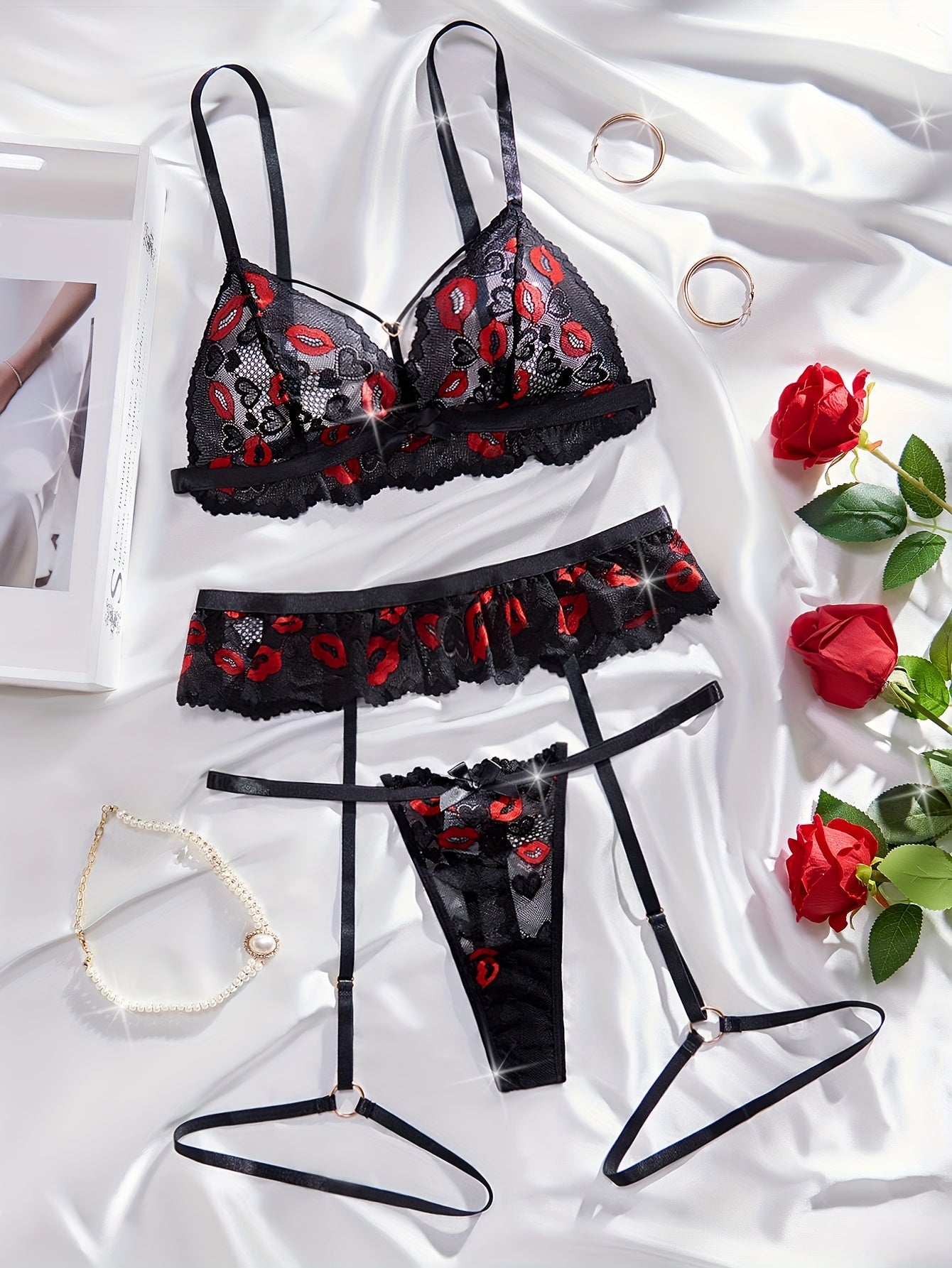 Lace lingerie set with red lips print and bow details. Includes transparent bra, G-string, and garter belt.