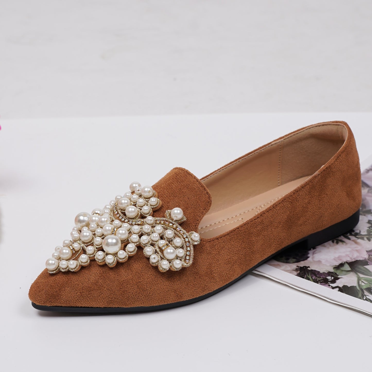 Women's elegant flat shoes with faux pearl decoration, point toe design, and lightweight comfort.