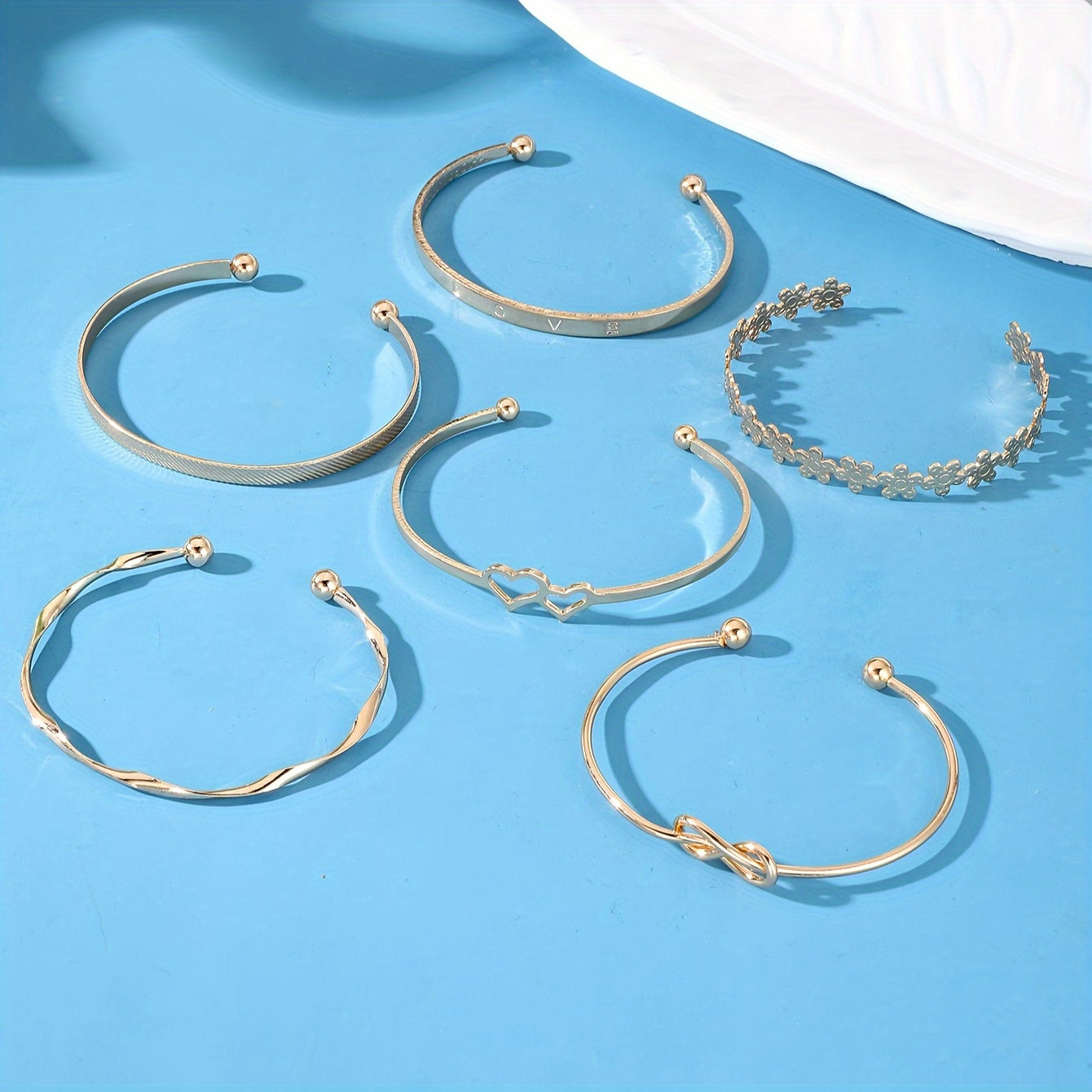 Set of 6 stylish bracelets featuring trendy flower, knot, and heart designs. Mix and match with your daily outfits or party wear. These adjustable jewelry pieces are perfect for accessorizing any look.