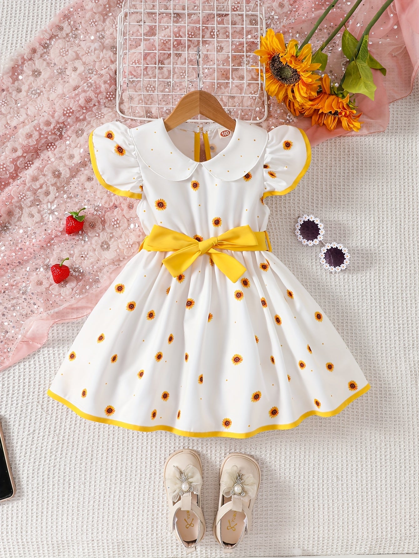 Girls' sleeveless dress with doll collar, ruffled hem, and strawberry design.