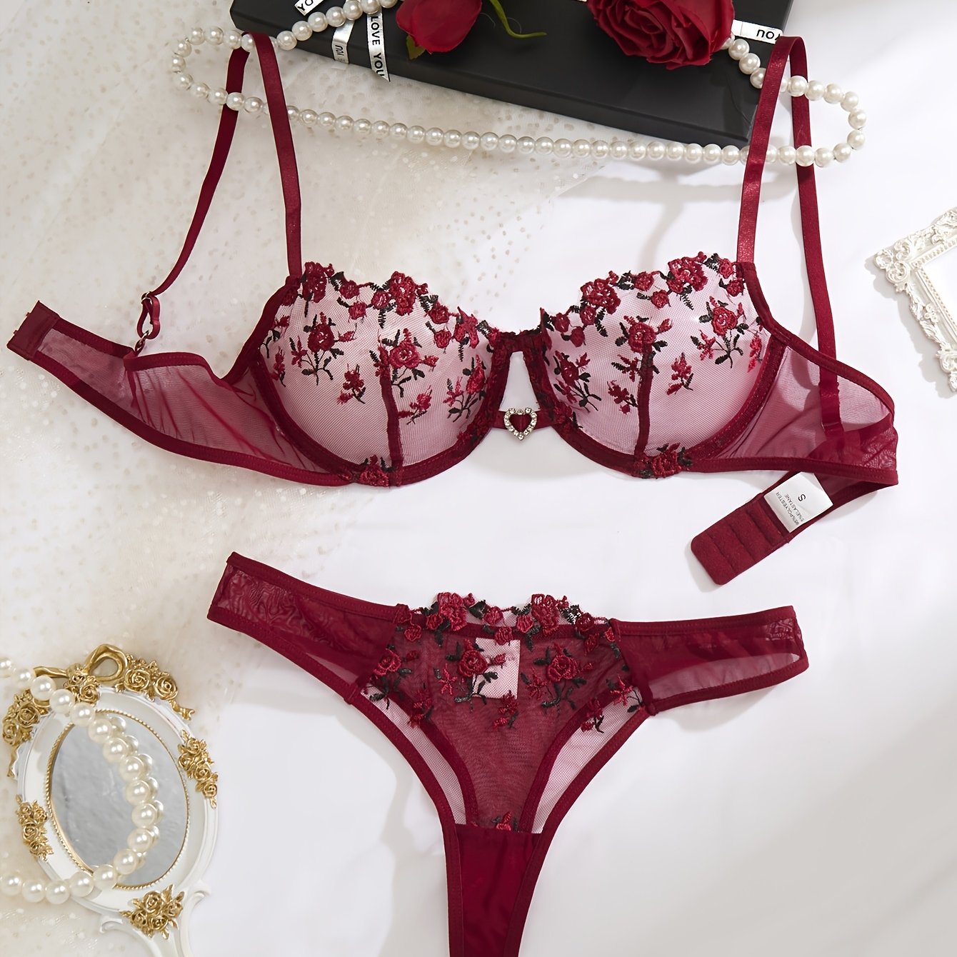 Red floral embroidered lingerie set for women with sheer mesh bra and low-rise panties. Hand washable, made from polyester and elastane blend.