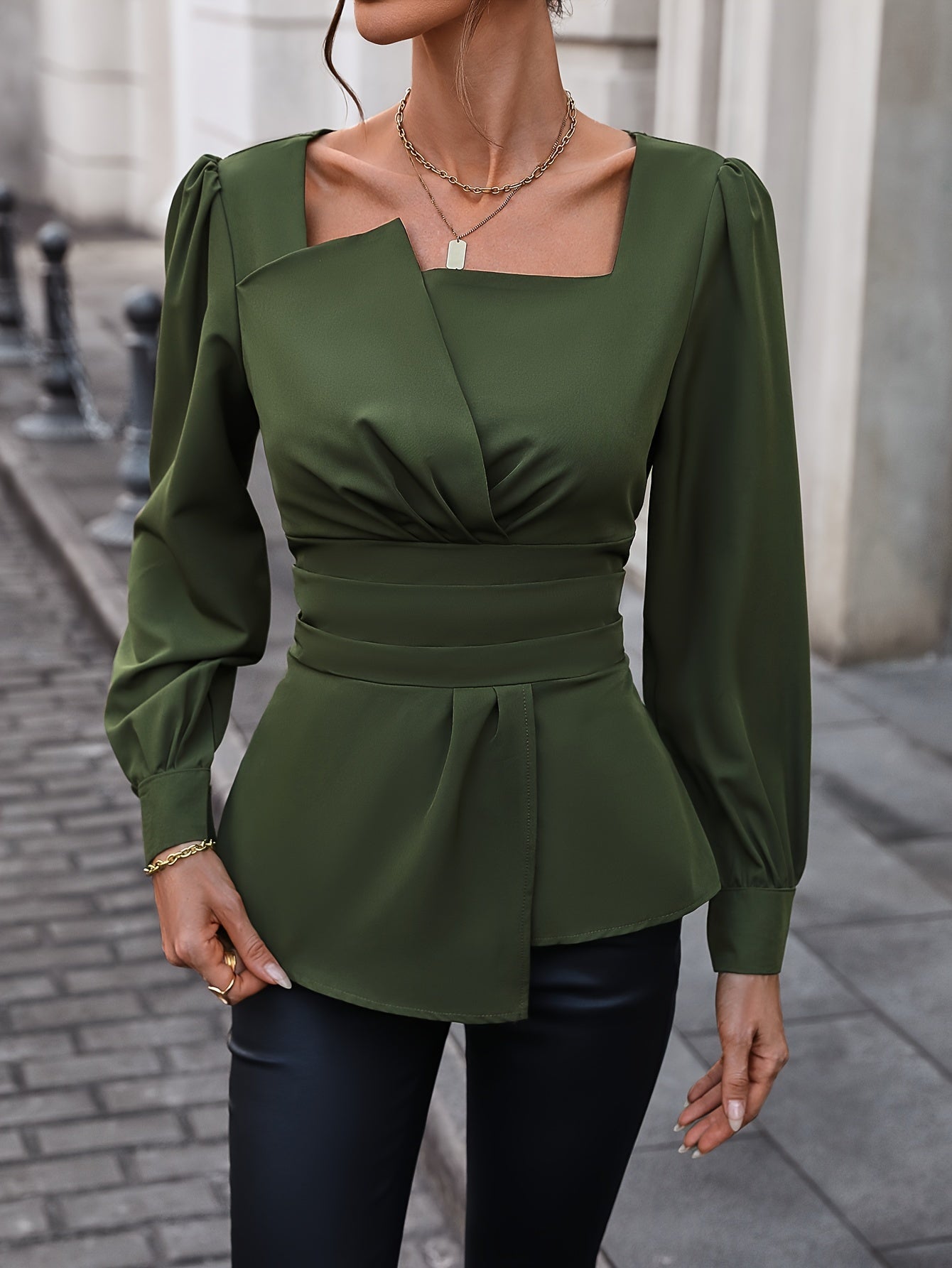 Sophisticated olive green blouse with square neckline, puffed sleeves, and asymmetric hem. Ideal for spring and summer, machine washable and dry cleanable.