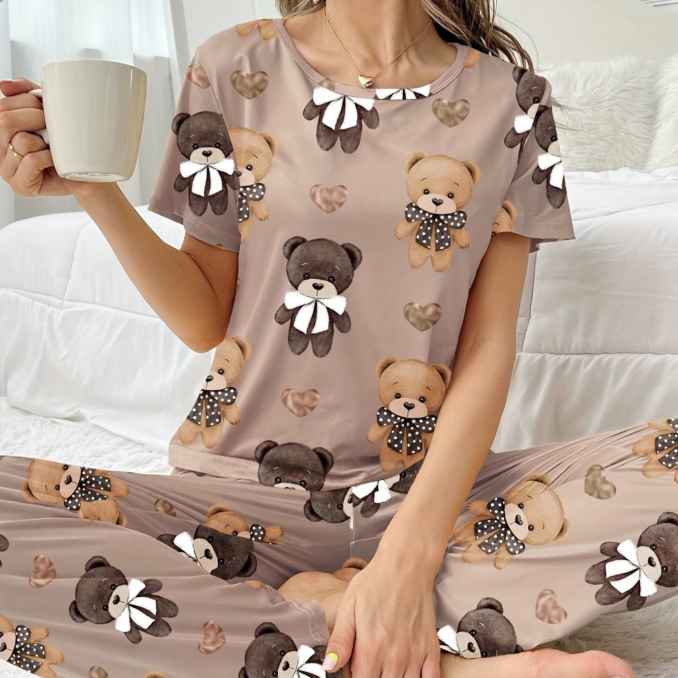 Women's sleepwear set with cartoon bear and heart print, featuring a cozy short sleeve top and elastic pants.