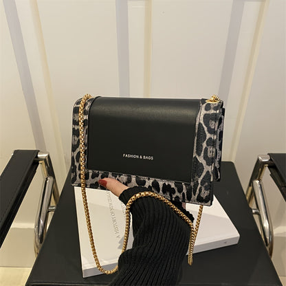 Stylish leopard print crossbody bag for women in black synthetic leather with golden-tone chain strap. Magnetic closure and large capacity, suitable for work, travel, and everyday use.