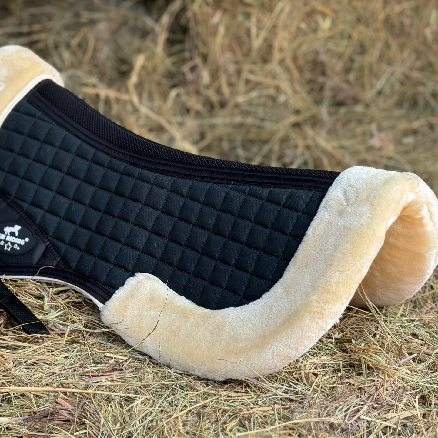 English saddle horse half pad with 100% woven fabric outer and shape-retaining foam insert, featuring a thick, soft, non-shedding synthetic sheepskin for easy cleaning.