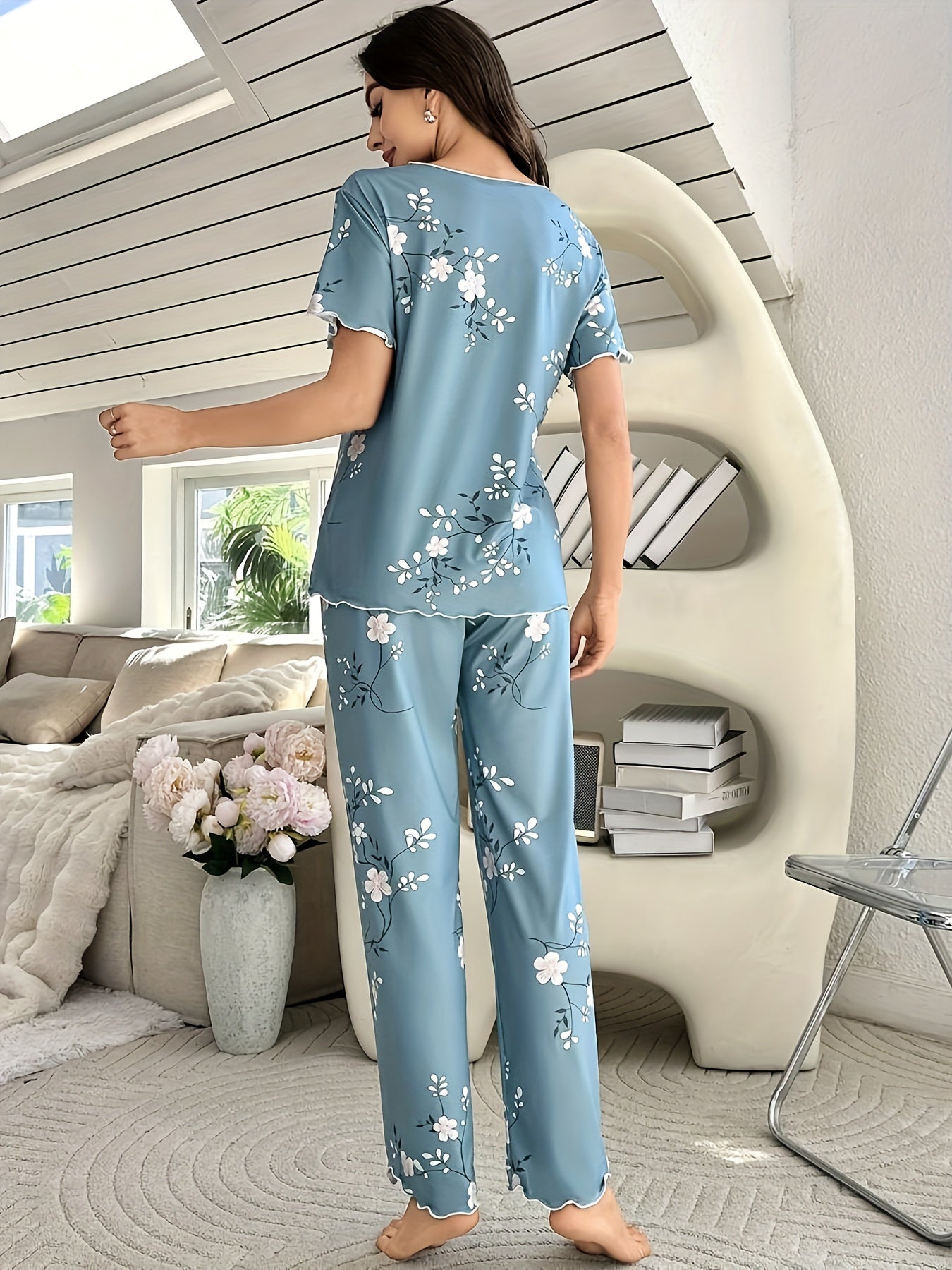 Women's sleepwear set with floral print, frill trim, short sleeve top, and elastic pants.