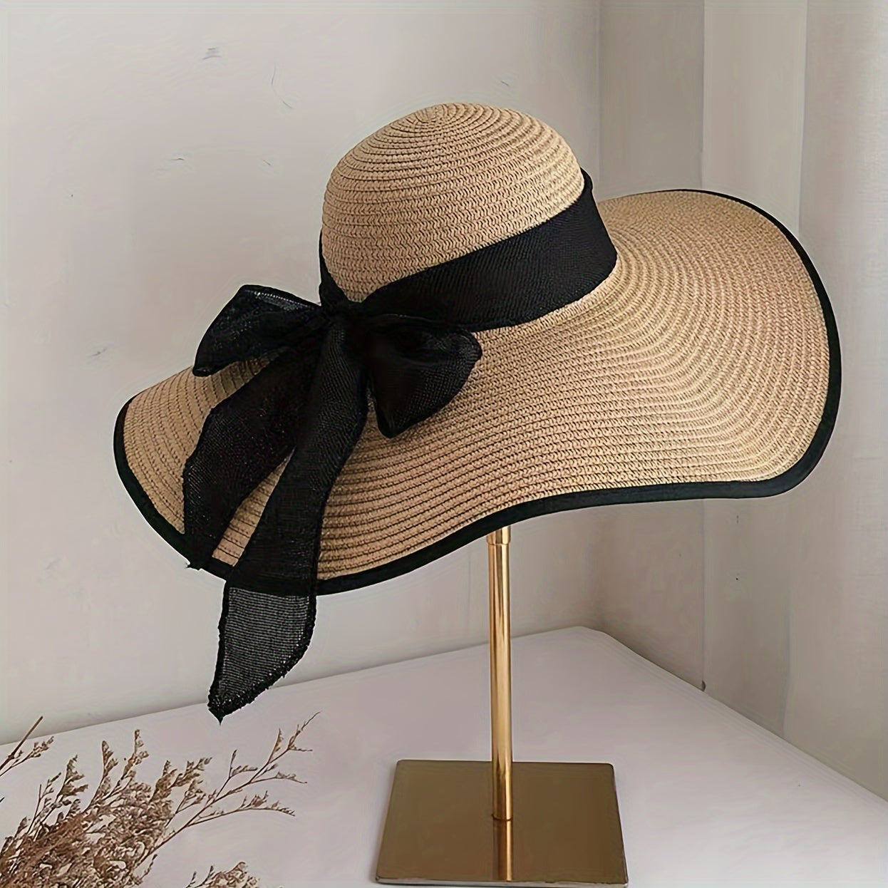 Casual wide brim sun hat with bow, ideal for stylish sun protection at the beach.