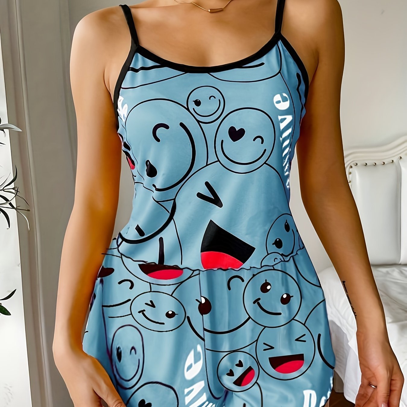 Women's sleepwear set with smiling face print cami top and elastic shorts.